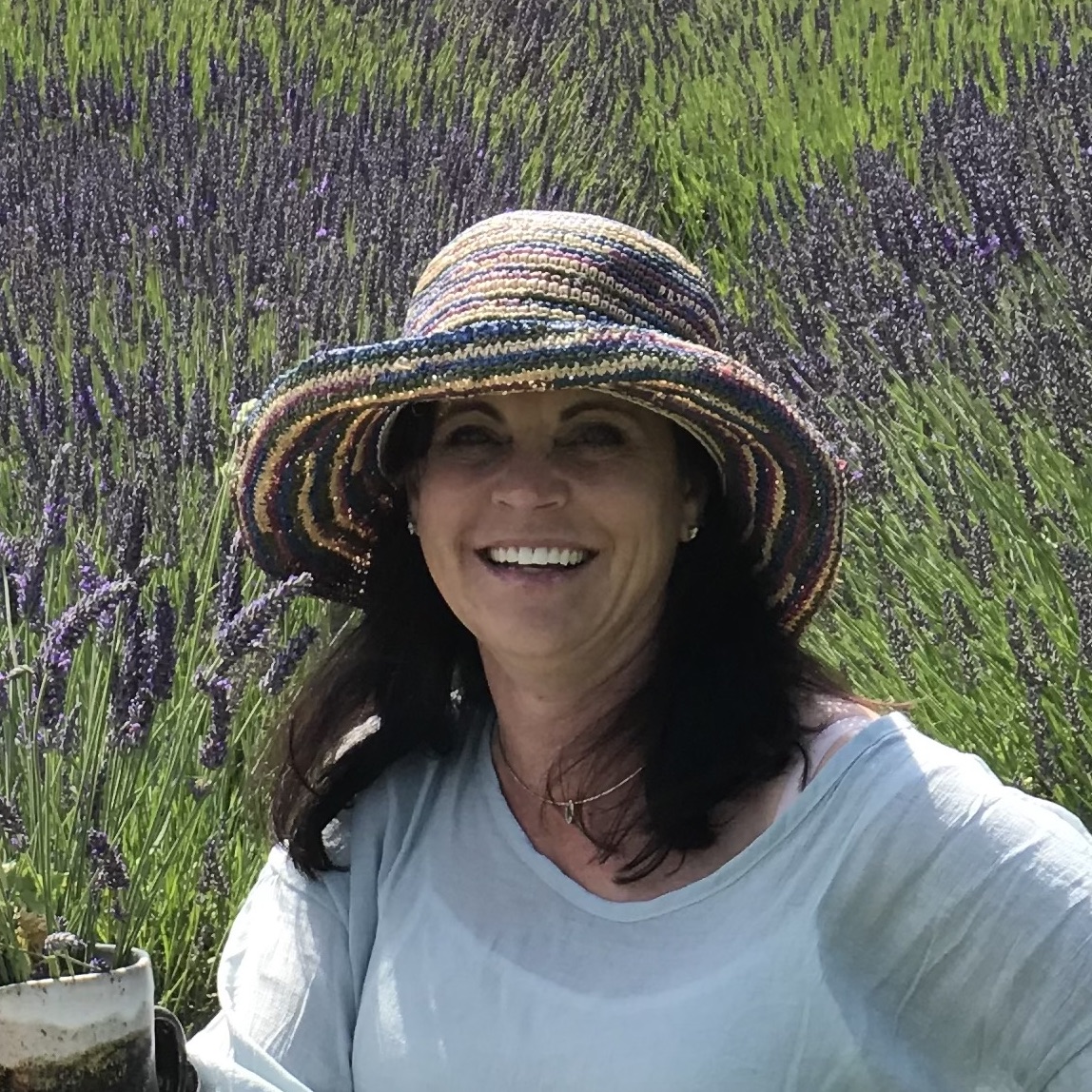 Image of Susan Paulsen wearing a sun hat in front of a field of lavender