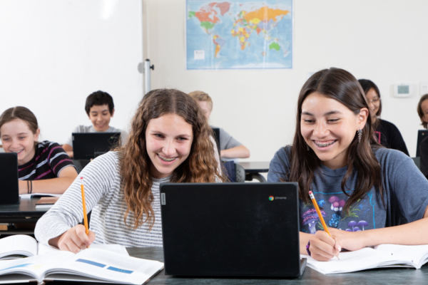 Students looking at an open laptop